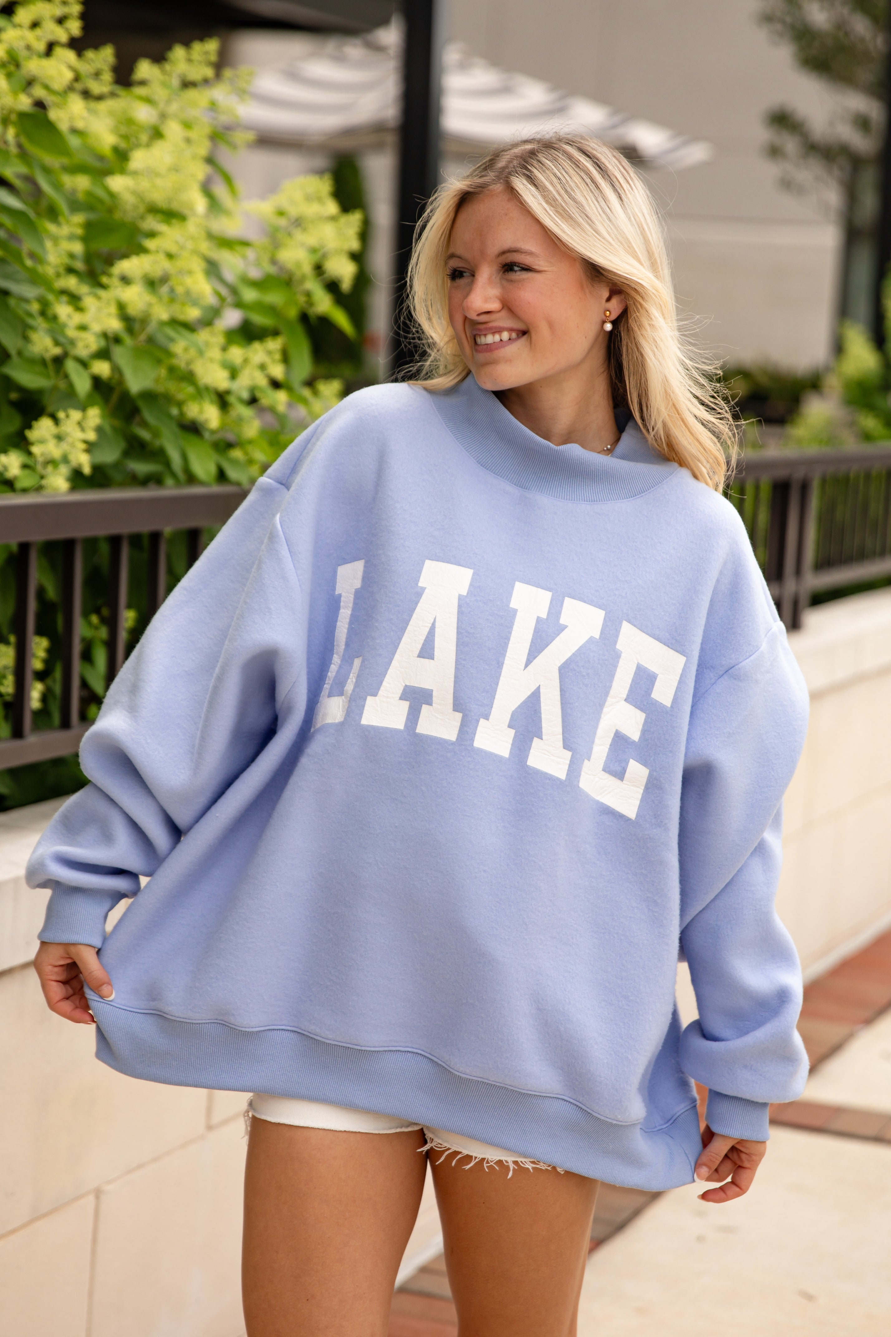 Woman wearing a light blue sweatshirt with &