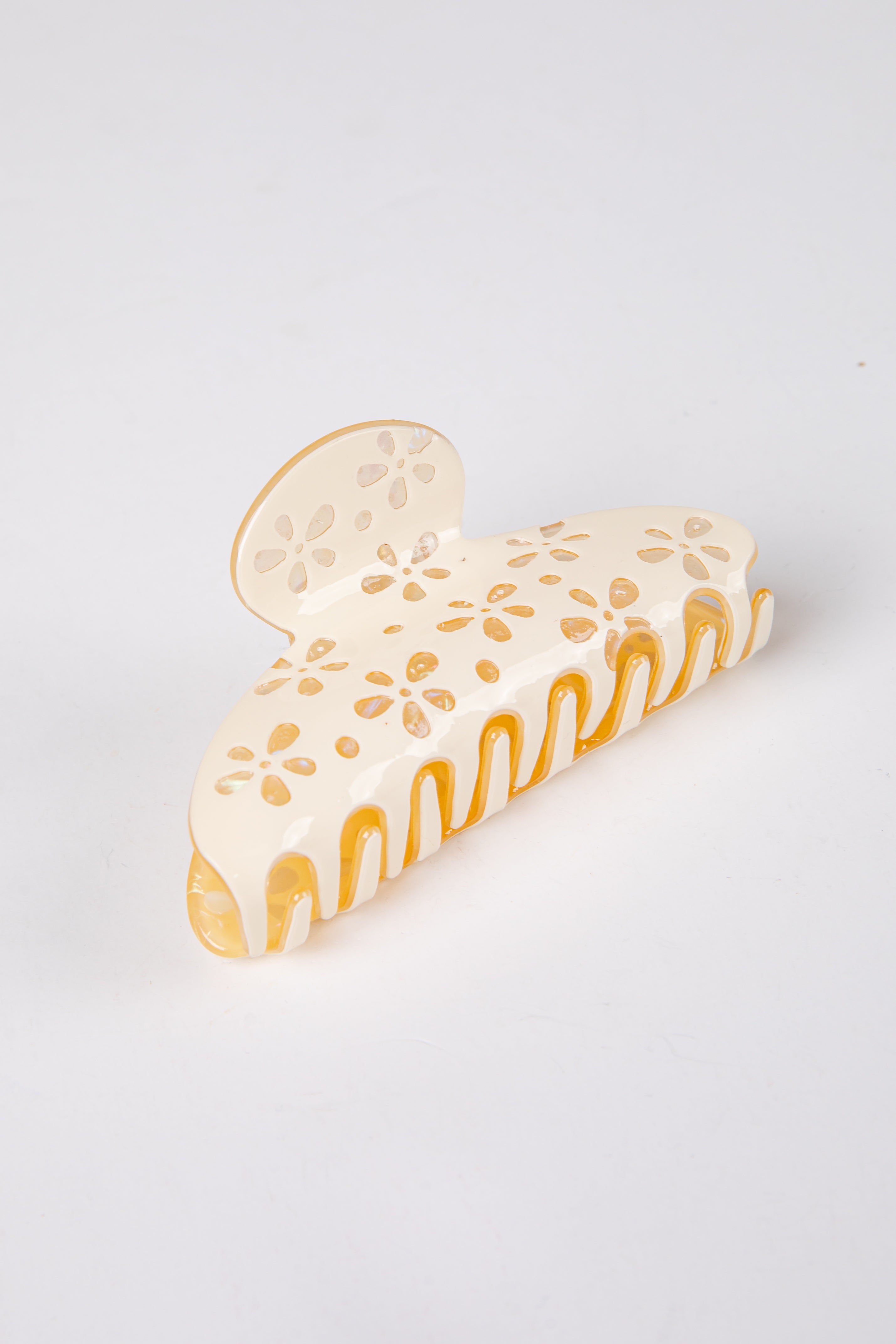 yellow claw clip with floral patterns on a light gray background