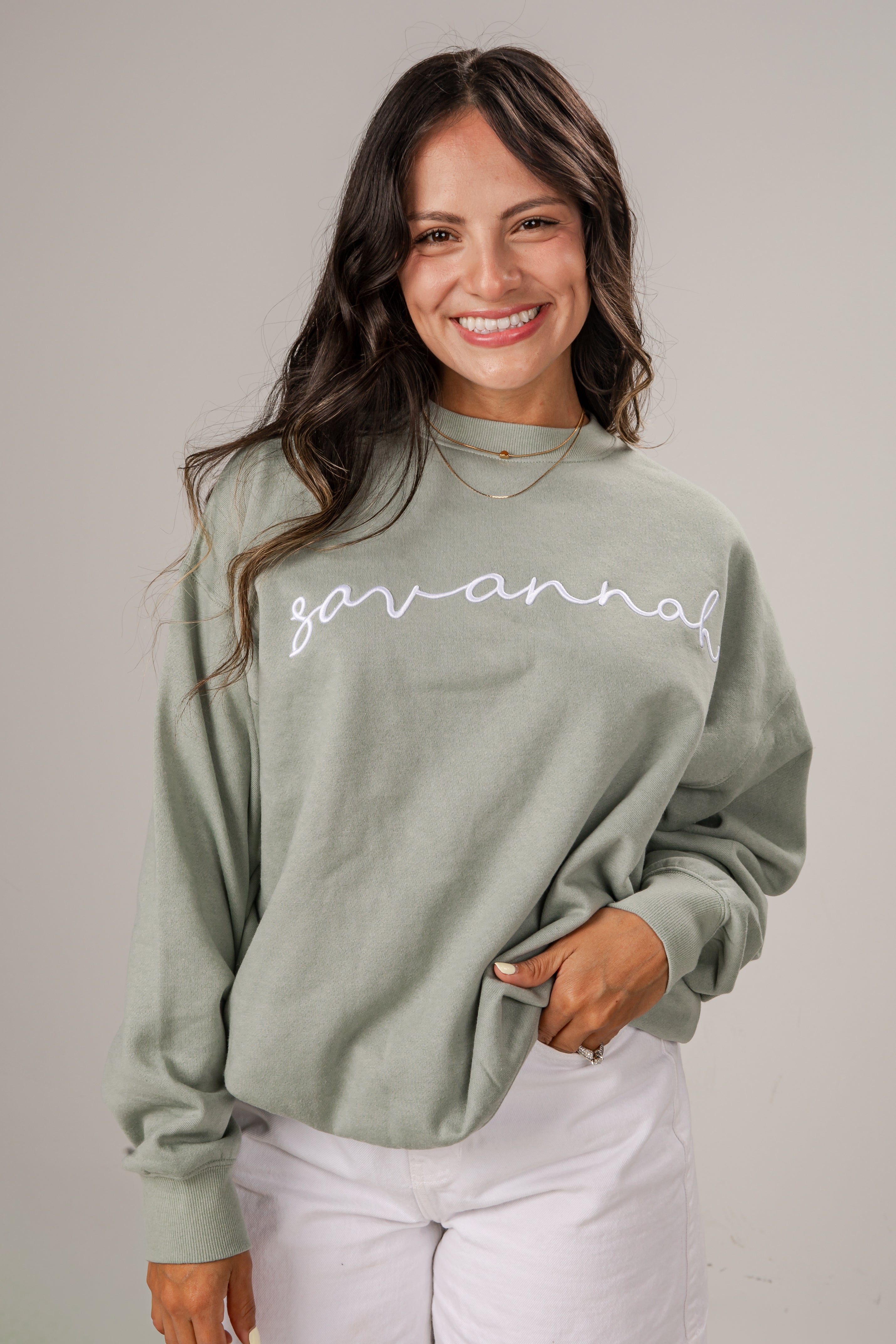 Woman wearing a green sweatshirt with &