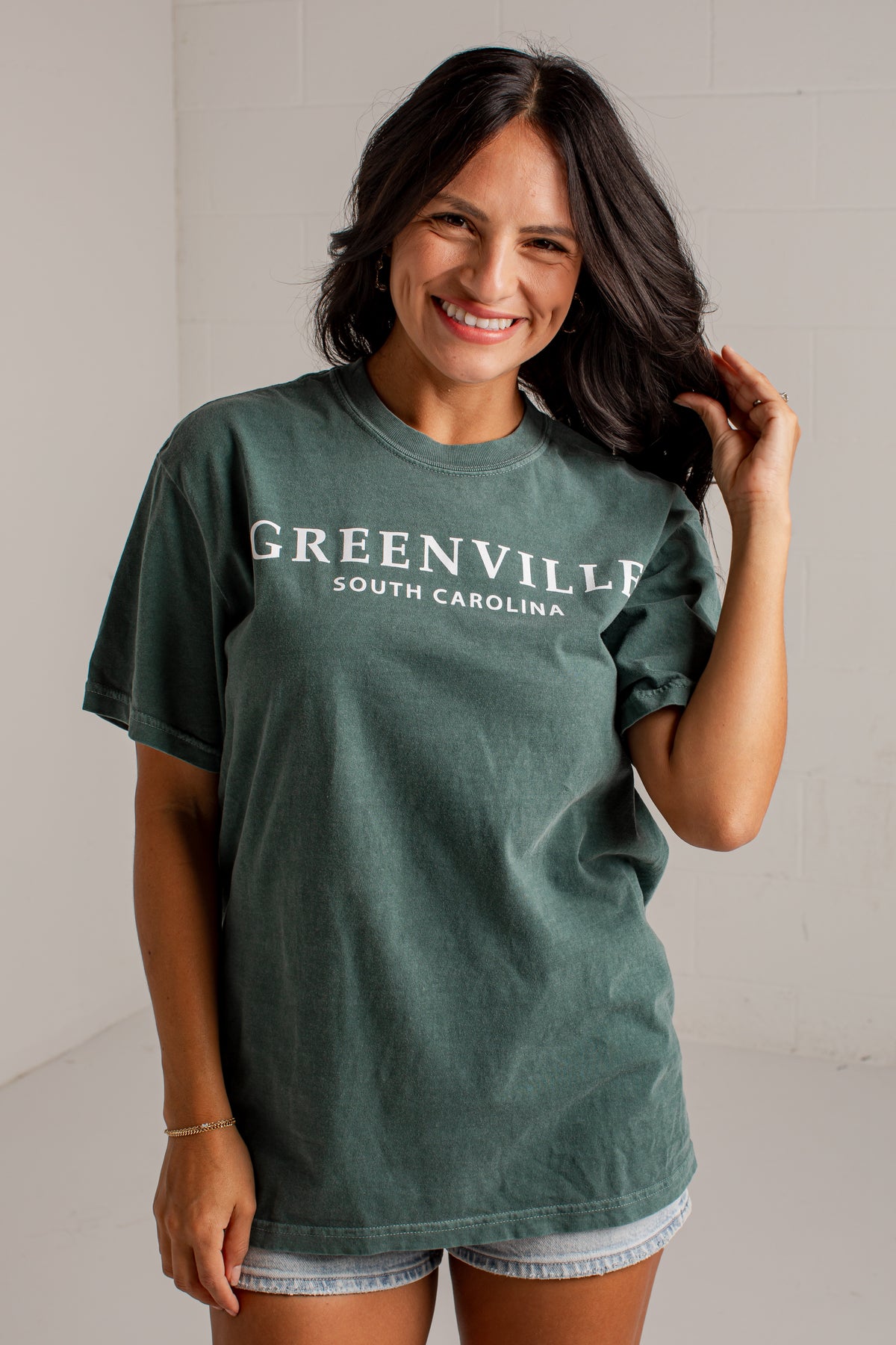 A woman wearing a faded dark green t-shirt with &