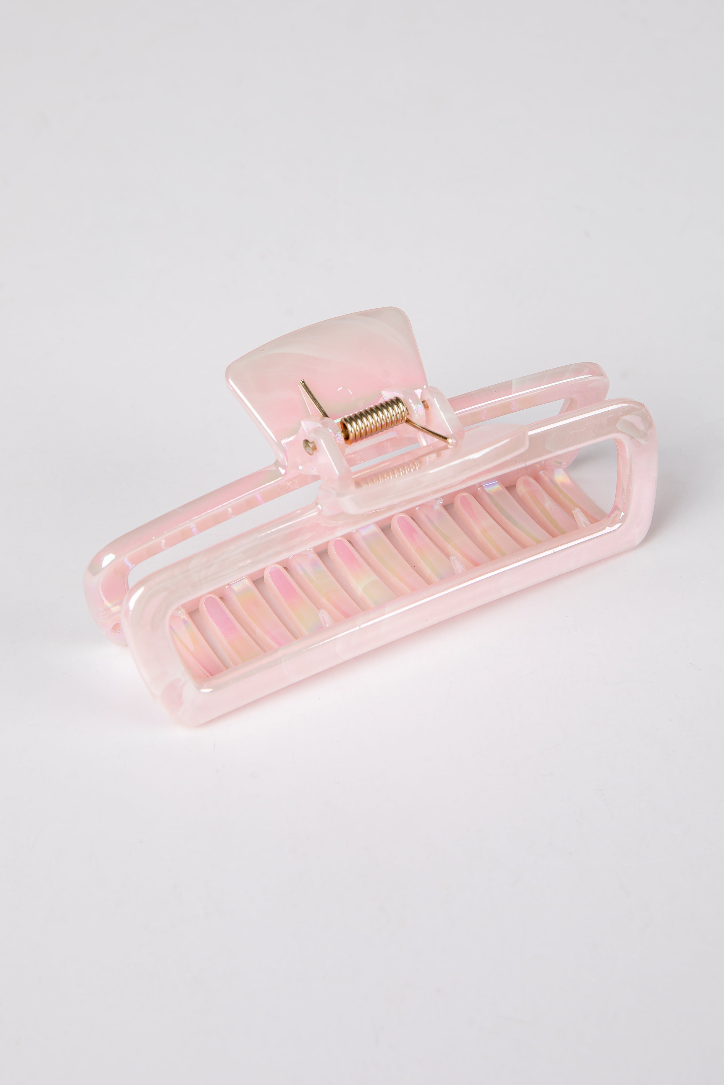 Pink hair clip on a light gray background