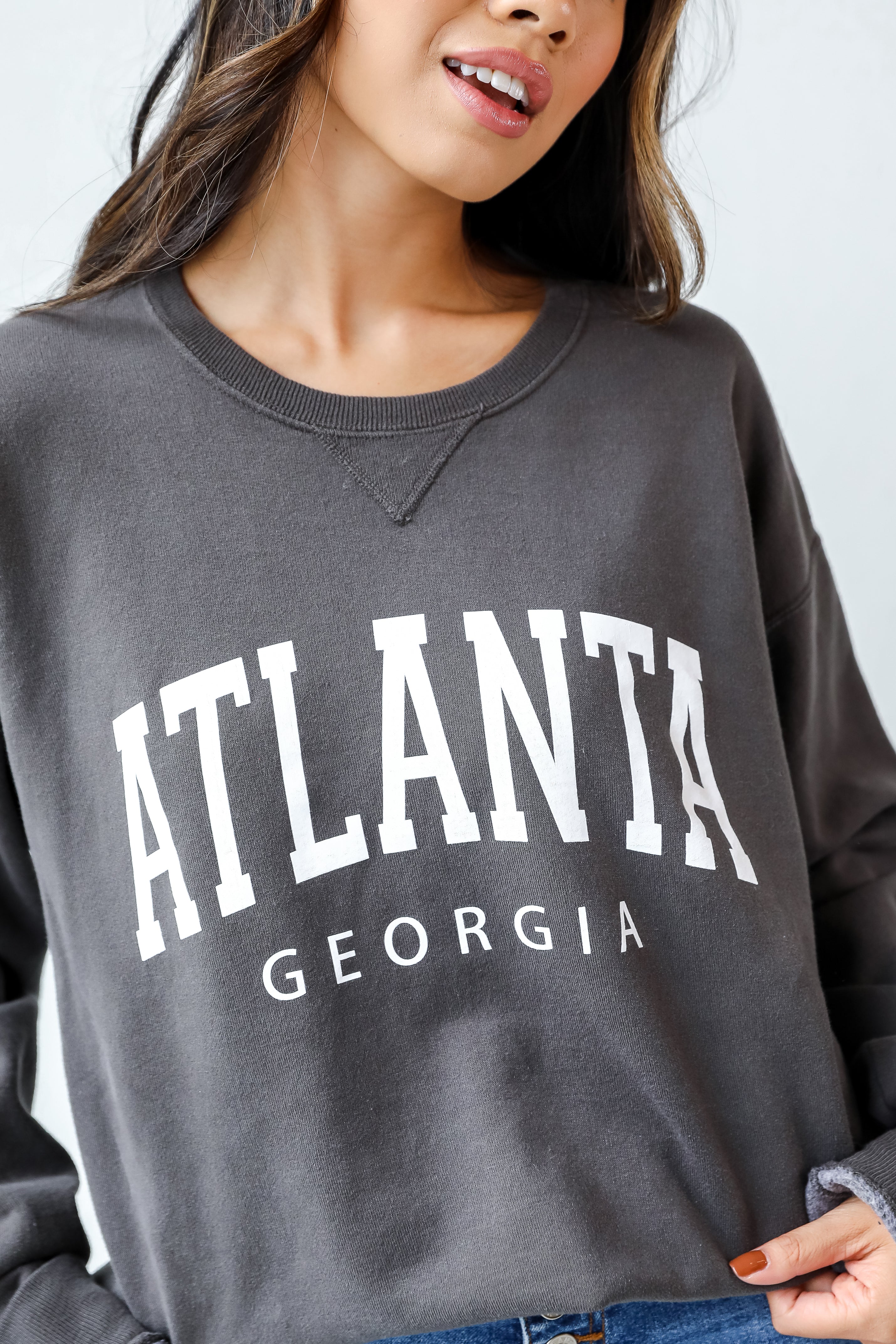 This comfy sweatshirt is designed with a soft and stretchy knit with a fleece interior. It features a crew neckline, long sleeves, a relaxed fit, and the words "Atlanta Georgia" on the front.