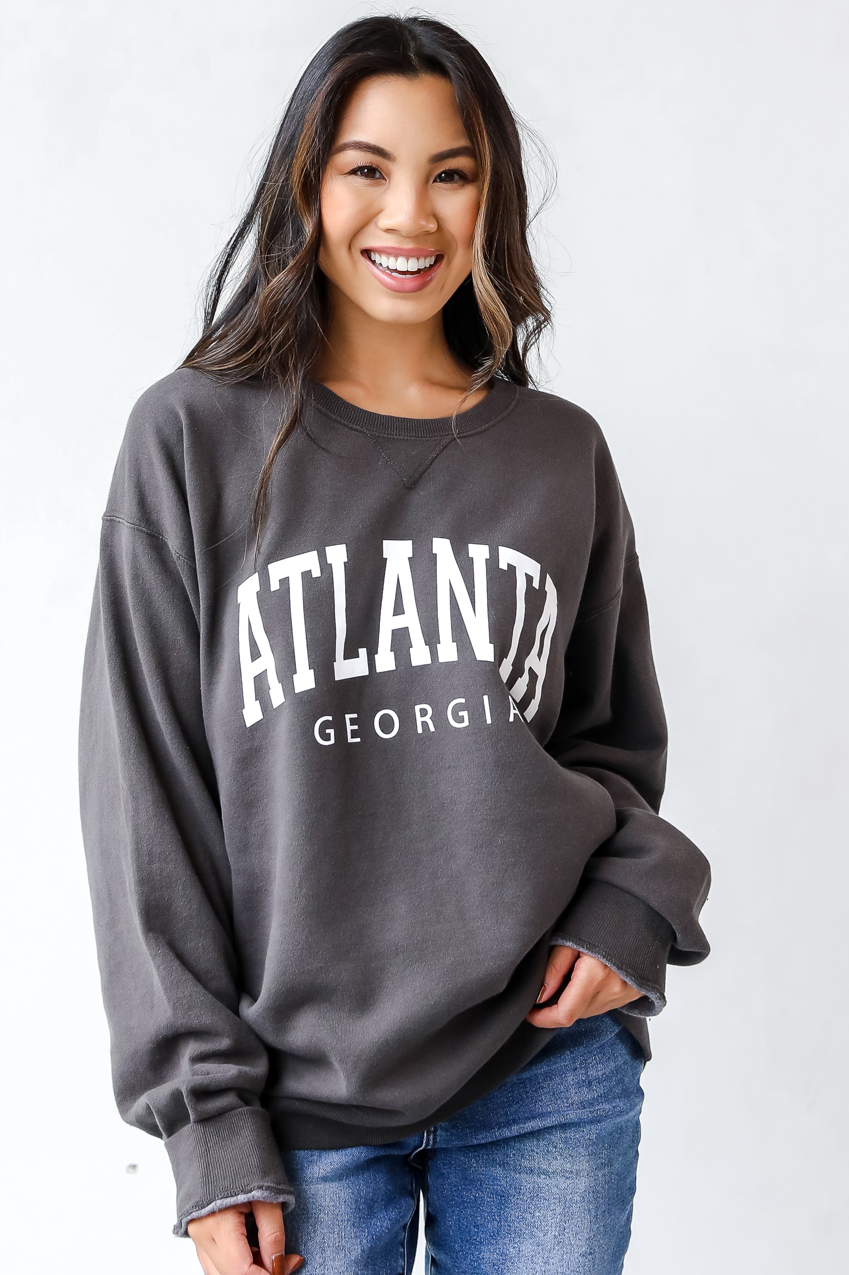 This comfy sweatshirt is designed with a soft and stretchy knit with a fleece interior. It features a crew neckline, long sleeves, a relaxed fit, and the words "Atlanta Georgia" on the front.