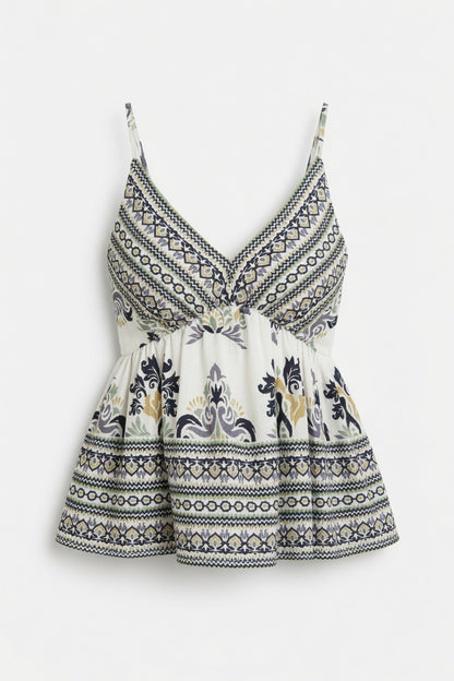 A sleeveless white camisole-style top with thin straps, a V-neckline, and a gathered peplum waist, featuring a navy and gray geometric border pattern and a central floral motif.