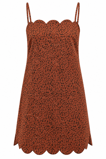 A rust-orange slip dress with a black leopard print pattern and scalloped edges, featuring thin spaghetti straps, shown against a plain white background.