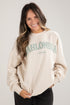 Woman wearing a beige sweatshirt with &