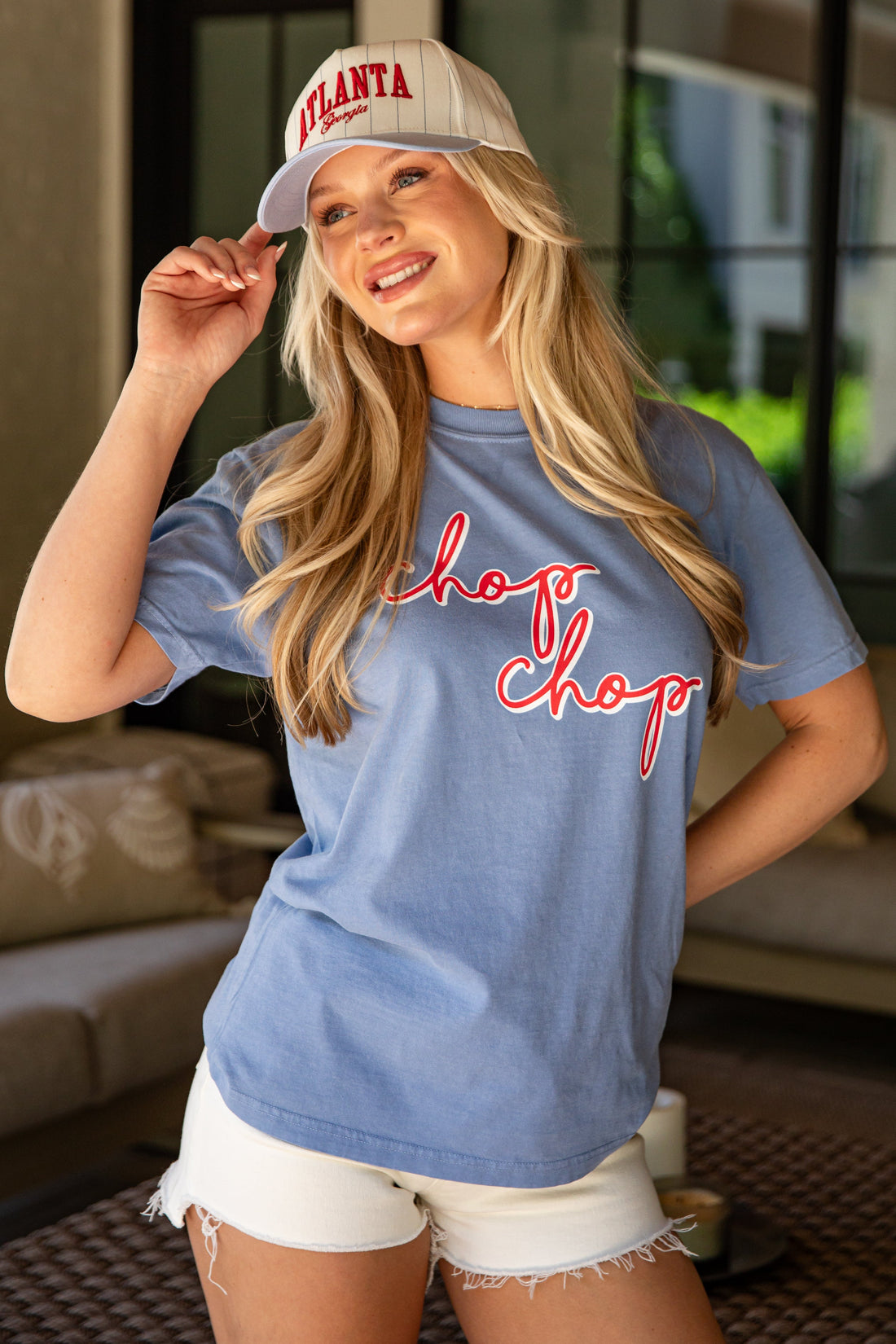 Woman wearing a blue 'chop Chop' t-shirt and white cap in an indoor setting
