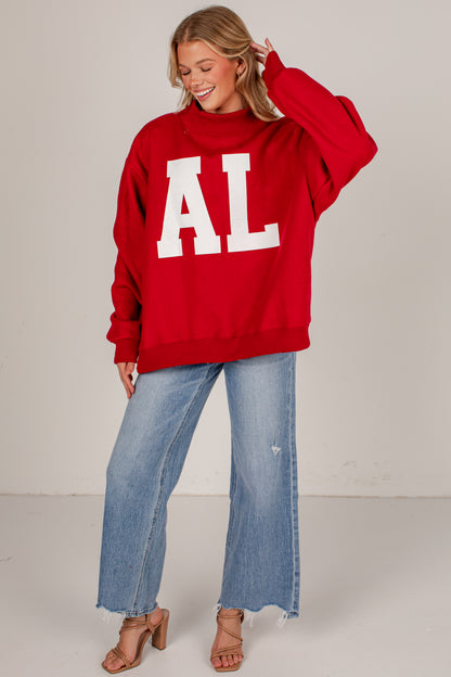 A woman modeling an oversized red sweatshirt with large white block letters &