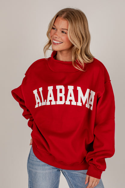 A smiling blonde woman wearing a red sweatshirt with &