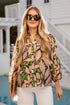 Woman wearing a patterned blouse and sunglasses by a poolside.