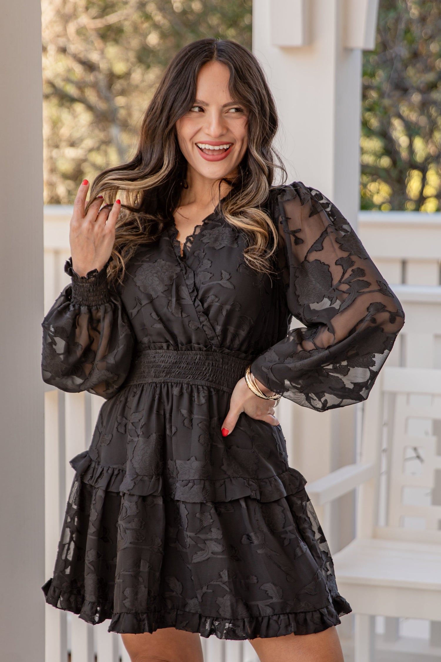 Woman wearing a black lace dress on a porch