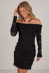 A woman modeling a black off-the-shoulder mini dress with long sheer lace sleeves and textured horizontal ruching, photographed against a plain light background.