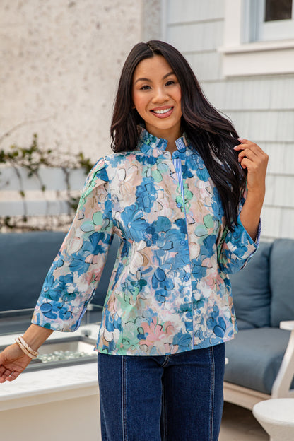 Woman wearing a floral blouse with a blurred outdoor background