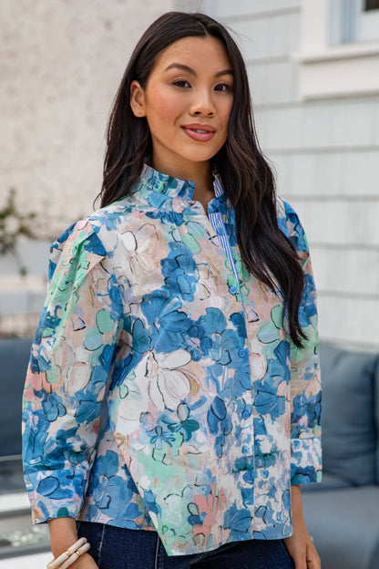 Woman wearing a colorful floral blouse outdoors