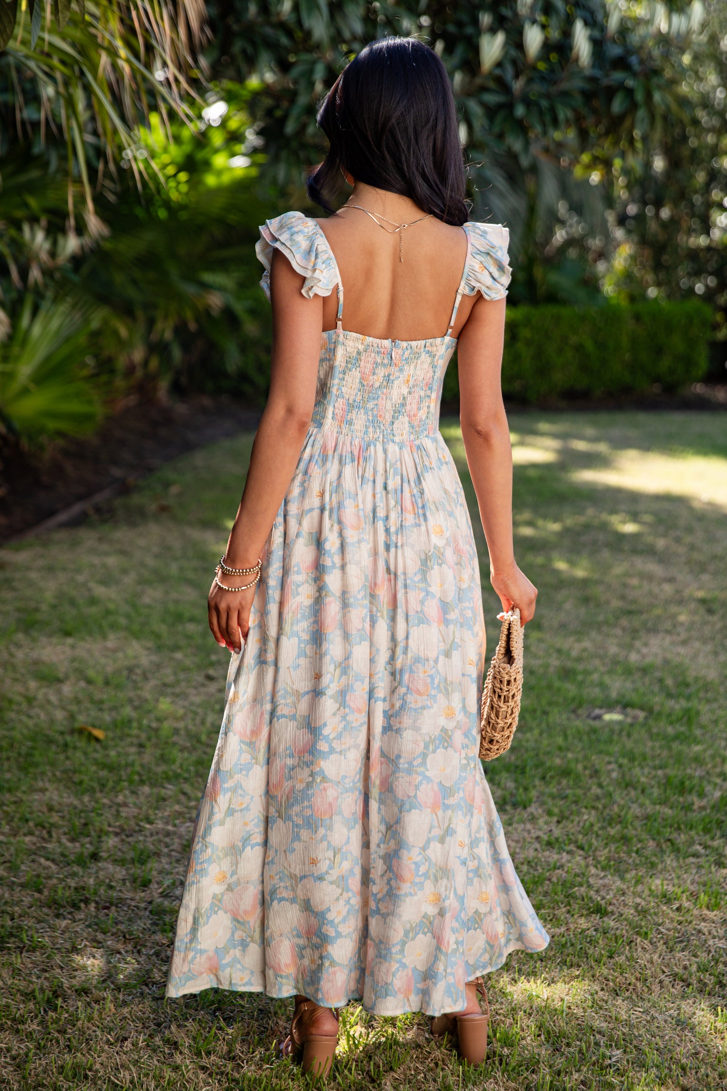 Woman in a floral dress standing in a garden