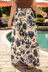 Person wearing a long floral pants by a poolside
