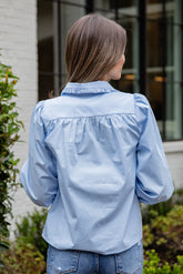 Woman wearing a light blue denim jacket outdoors