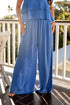 Person wearing a blue outfit on a balcony with greenery in the background