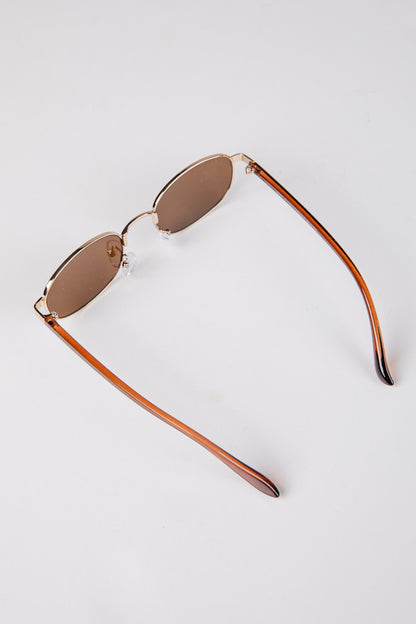 Sunglasses with brown gradient lenses on a light gray background