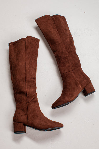 A pair of knee-high brown suede boots with block heels, shown from different angles on a light off-white background.