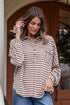 Woman wearing a striped shirt and jeans standing on a porch.