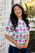 Woman wearing a colorful floral-patterned shirt outdoors