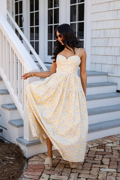 Woman in a yellow dress standing on a staircase outside a house