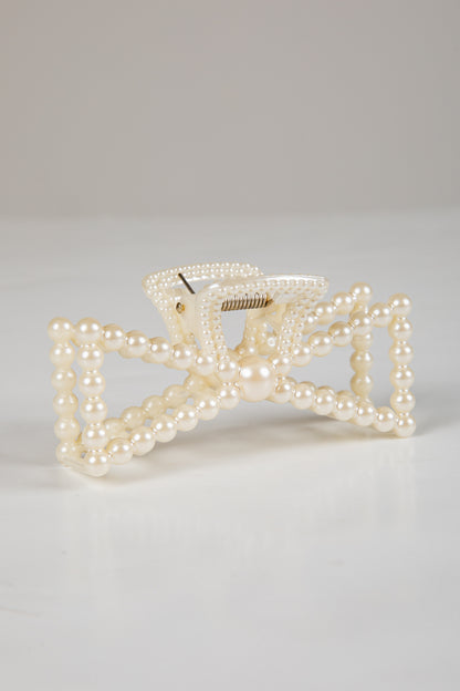 Pearl bow hair clip on a light gray background