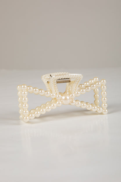 Pearl-handled clutch bag on a light gray background