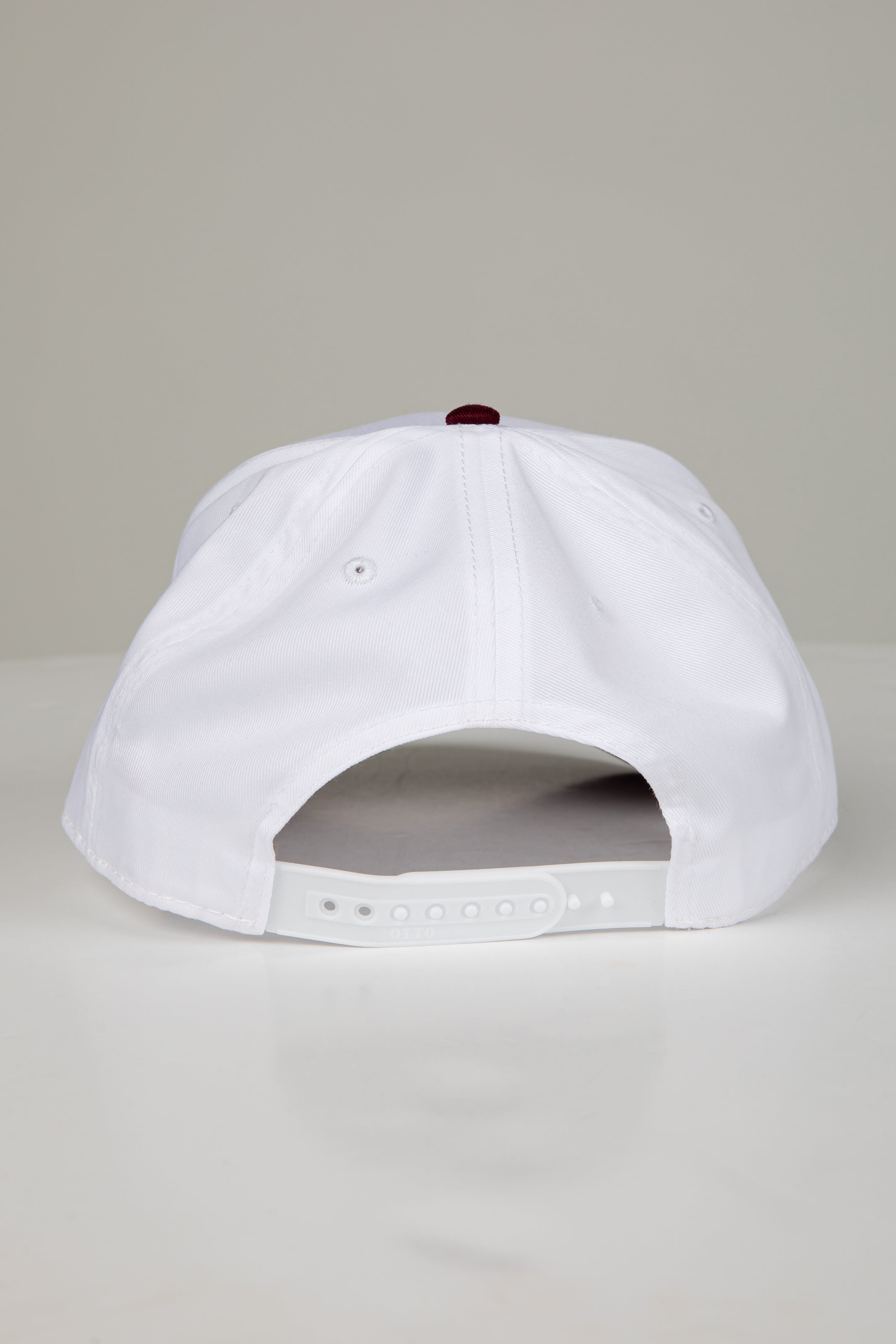 White cap with a red logo on a gray background