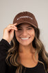 Person wearing a brown cap with &