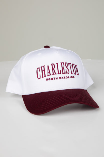 White cap with maroon brim and text on a white background