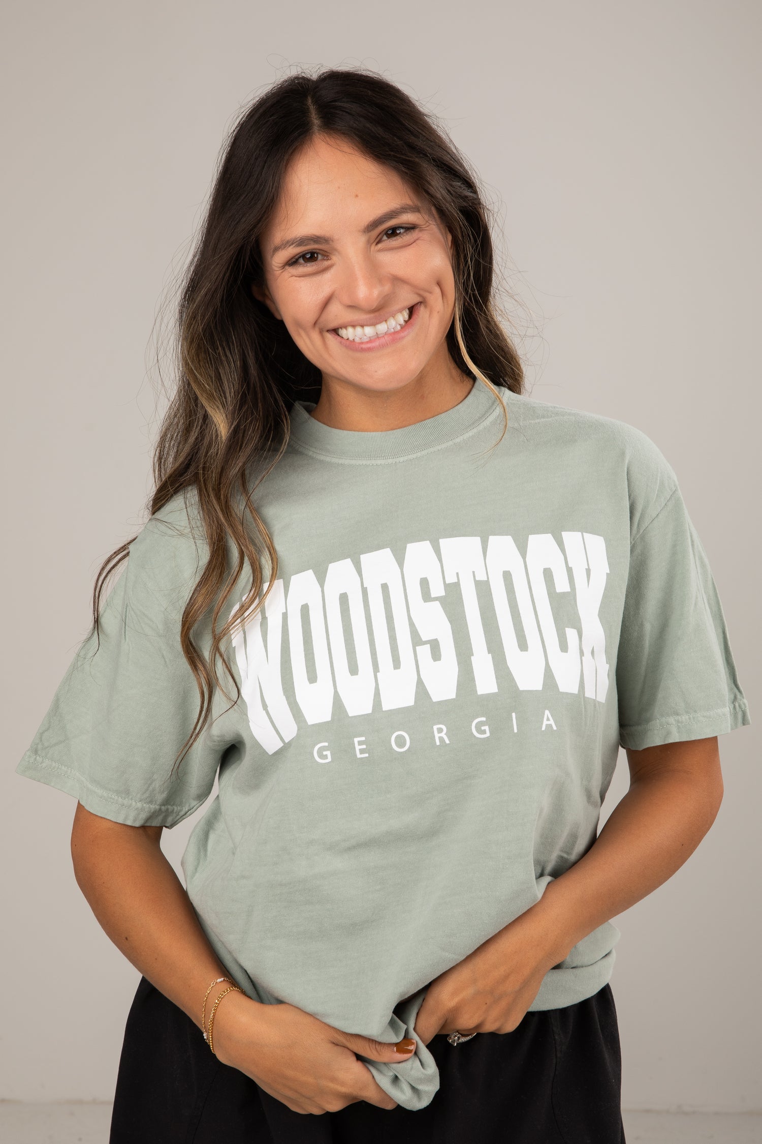 Woman wearing a green t-shirt with &