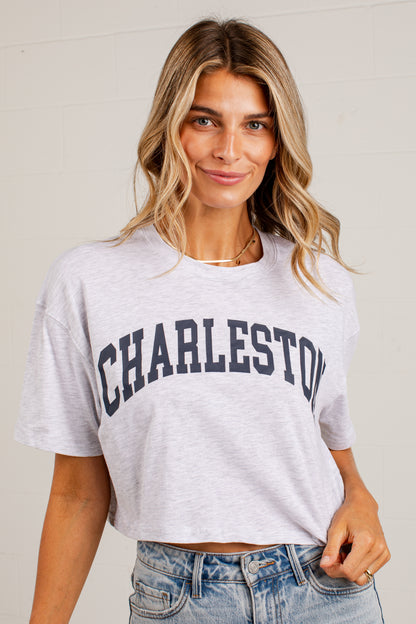 A woman wearing a light heather gray cropped t-shirt with &