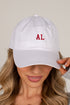 A woman wearing a white baseball cap with red embroidered letters &