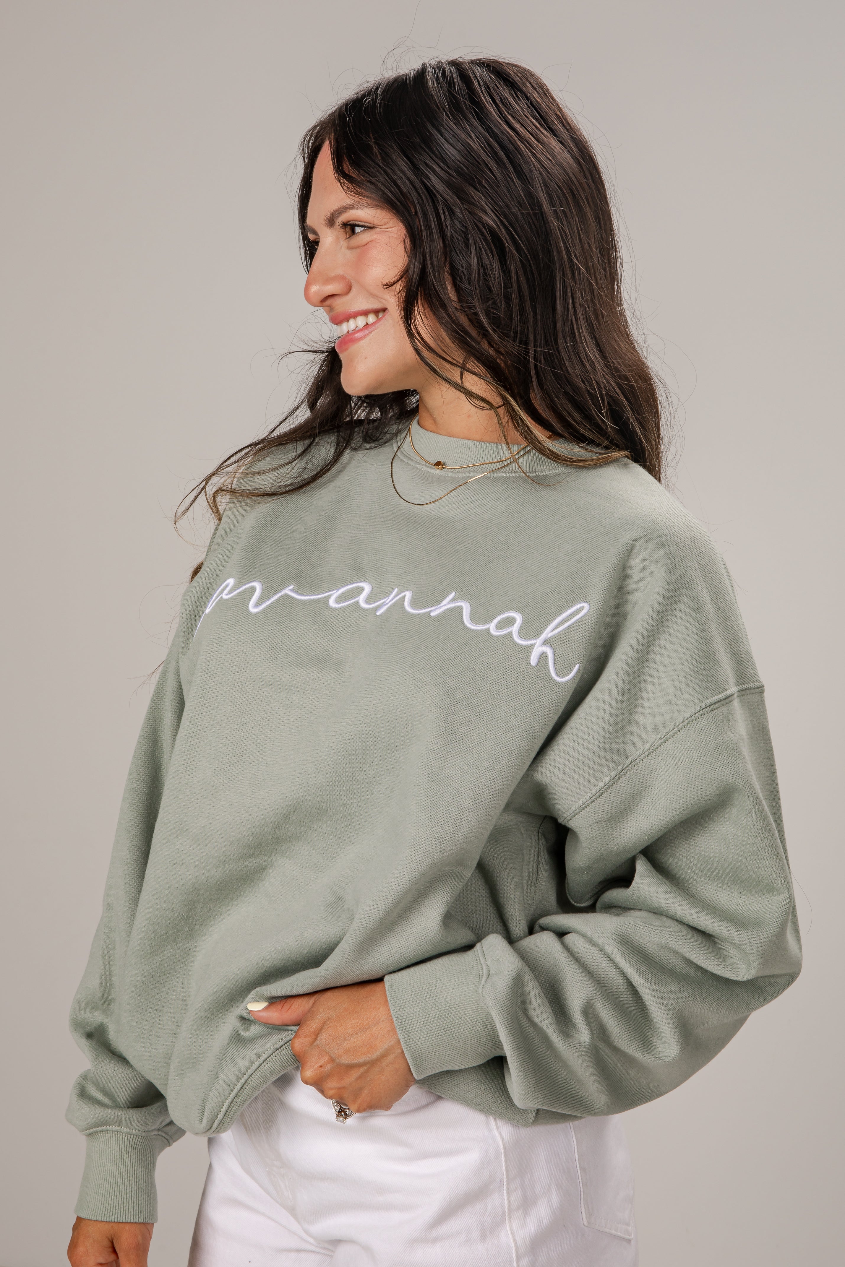Woman wearing a green sweatshirt with &