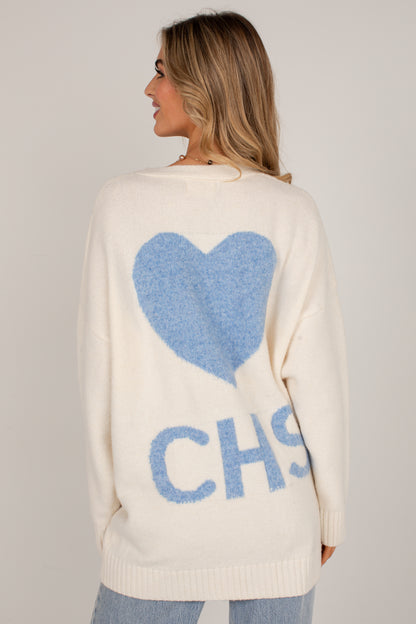 A woman shown from the back wearing a cream knit sweater with a large blue heart and the letters &