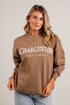 A woman wearing a brown long-sleeve sweatshirt with &