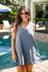 Woman in a blue dress standing by a pool