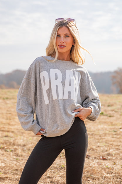 Woman wearing a gray sweatshirt with &