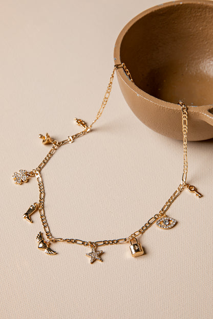 Gold bracelet with charms on a beige surface