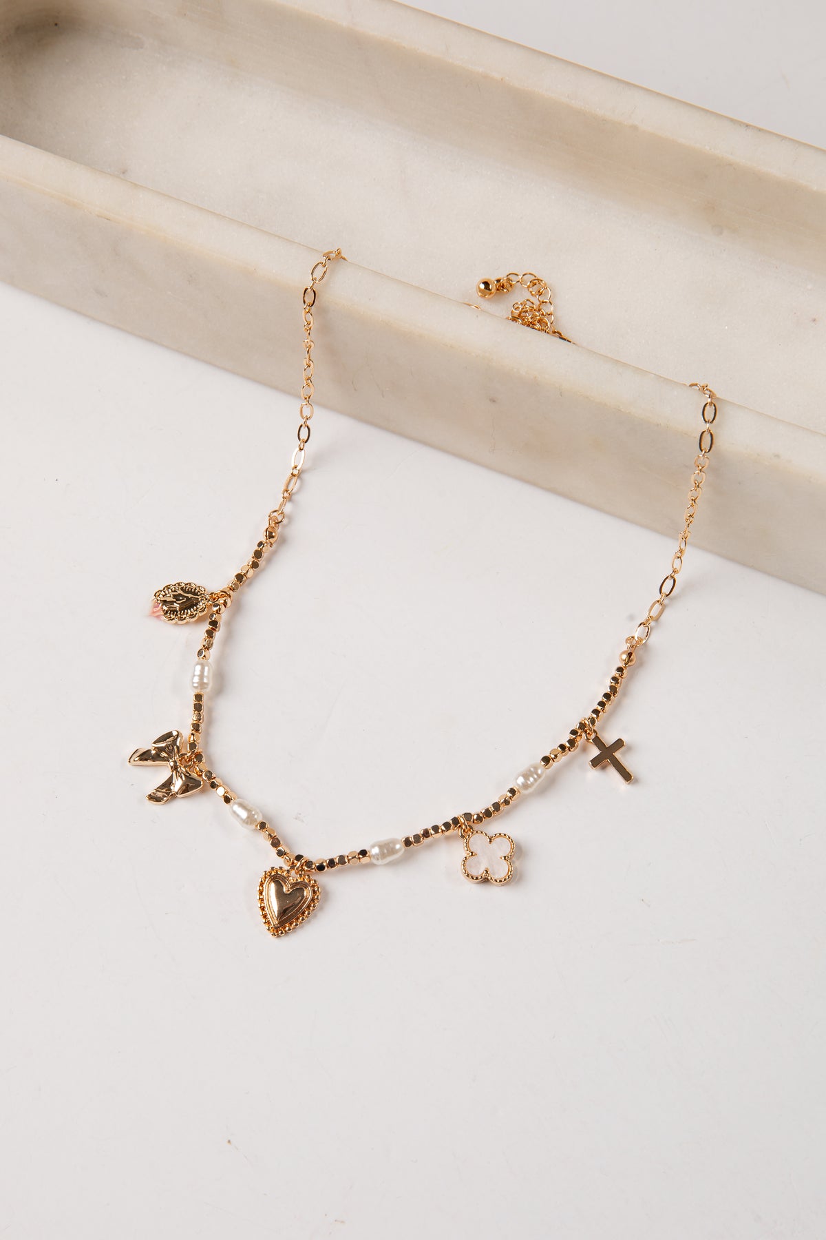 Gold necklace with heart-shaped charms on a light background