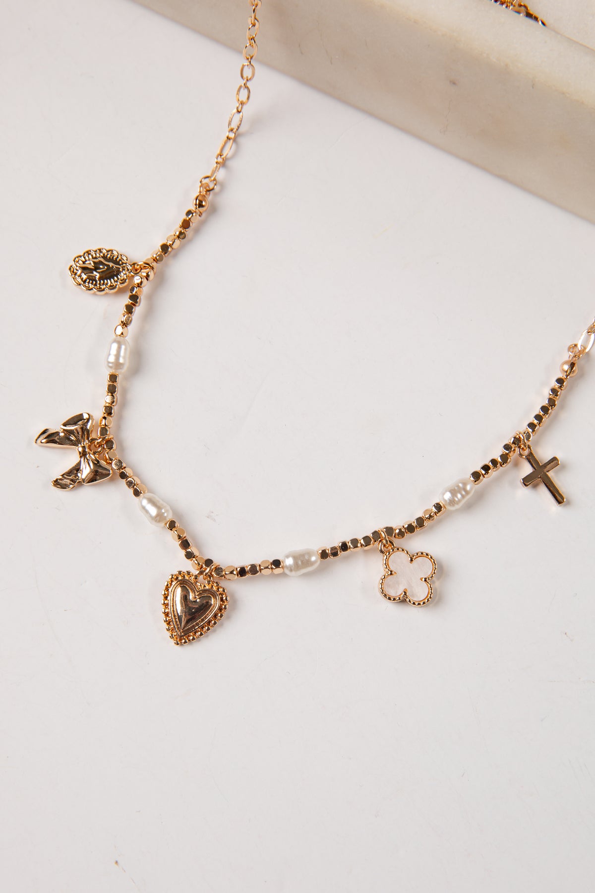 Necklace with various charms on a light background