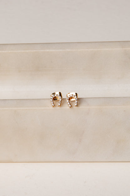 Rose gold elephant earrings on a beige background
