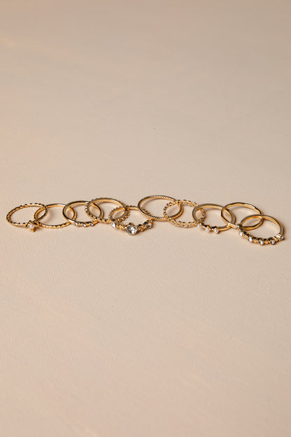Gold rings with charms on a beige background