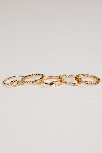 Set of gold chain rings on a light gray background