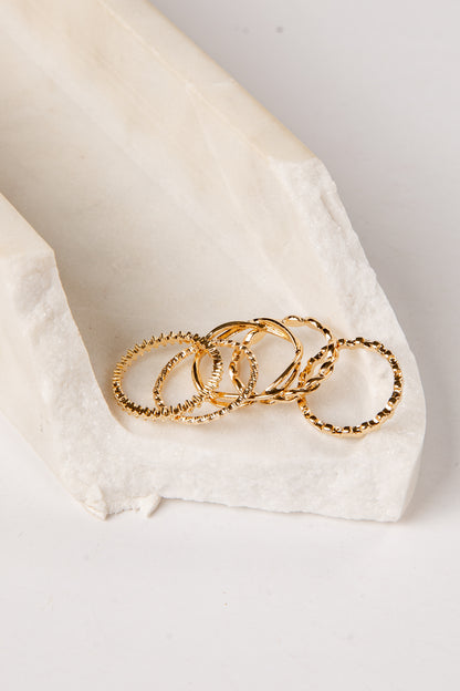 Gold rings on a white fabric surface