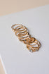 Set of gold hoop earrings on a light gray surface