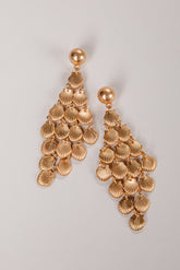 Gold shell-shaped earrings on a light gray background
