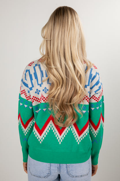 Person wearing a colorful patterned sweater with a plain background